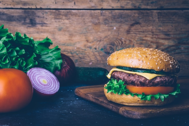 Hausgemachte Burger (Cheeseburger) mit Rindfleisch auf einem hölzernen Hintergrund. Klassischer hausgemachter Burger.