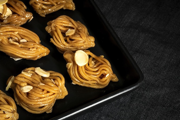 Hausgemachte Chebakias Gebäck typische marokkanische Süßigkeiten mit Honig für Ramadan und Hilfe auf dunklem Hintergrund Halal Food