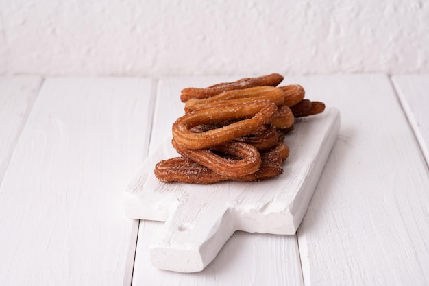 Hausgemachte Churros auf weißem Holzhintergrund