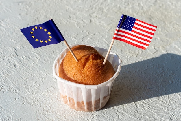 Hausgemachte Cupcake mit USA und EU-Flaggen auf weißem Hintergrund Das Konzept der Zusammenarbeit zwischen den Ländern Das Konzept der Handelsbeziehungen zwischen den Ländern