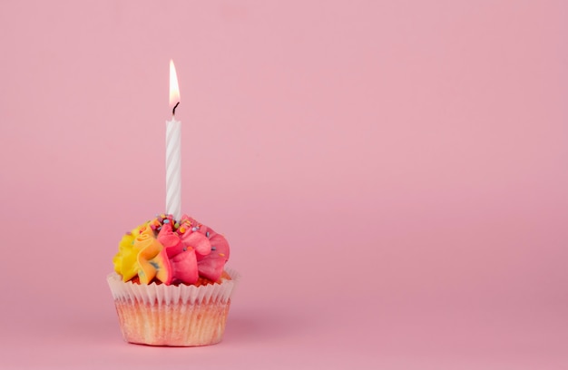 Hausgemachte Cupcakes mit mehrfarbiger Creme auf einem rosa Hintergrund kopieren Raum. Gelbe und rosa Creme.