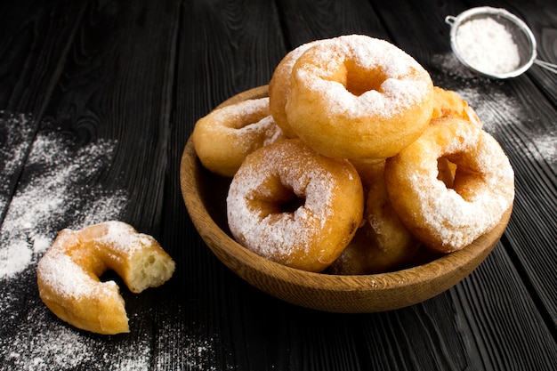 Hausgemachte Donuts mit Puderzucker in der braunen Schüssel