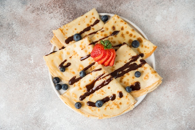 Hausgemachte dünne Pfannkuchen mit Beeren und Schokolade