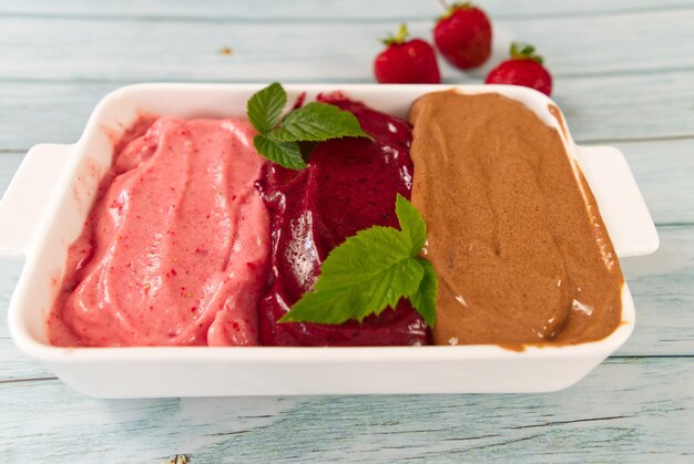 Hausgemachte Eiscreme gemischte Aromen in einem Teller Süßes Dessert aus Erdbeeren, Blaubeeren und Schokolade