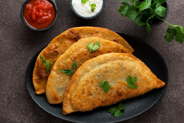 Hausgemachte Empanadas mit Füllung und Tomatensauce