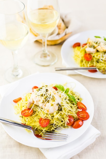 Hausgemachte Engelshaarnudeln mit Pestosauce, gerösteten Kirschtomaten und gegrilltem Hähnchen.