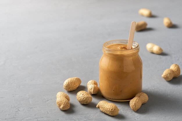 Hausgemachte Erdnussbutter in Gläsern auf der Betonoberfläche