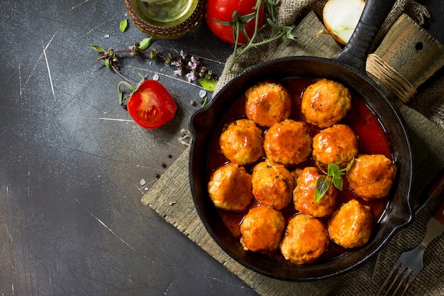 Hausgemachte Fleischbällchen mit Gewürzen und Tomatensauce in einer Bratpfanne Flacher Draufsichthintergrund