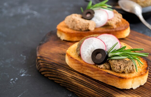 Hausgemachte Fleischpastete auf geröstetem knusprigem Brot. dunkler Fotostil.