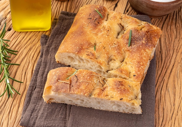 Hausgemachte Focaccia mit Salz, Olivenöl und Rosmarin über Holztisch