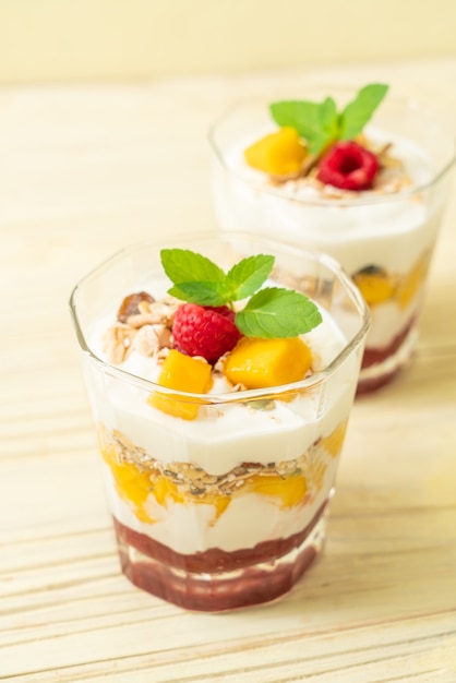 hausgemachte frische Mango und frische Himbeere mit Joghurt und Müsli - gesunde Ernährung