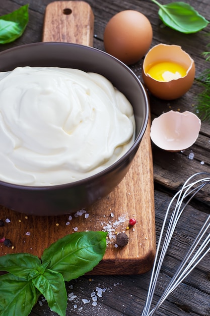 Hausgemachte frische Mayonnaise-Sauce in einer Schüssel neben Zutaten