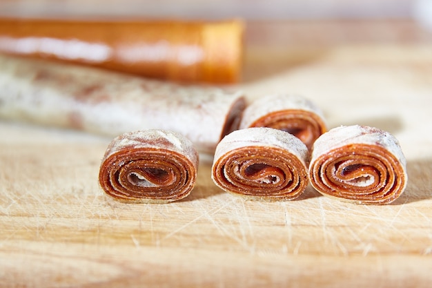 Hausgemachte Fruchtrollen auf einem Holzbrett, Bonbonpastillen für ein gesundes Frühstückskonzept, Kopierraum