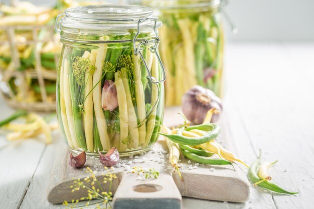 Hausgemachte gelbe und grüne Bohnen aus der Dose mit Gemüse aus dem Gewächshaus