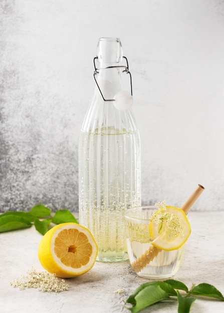 Hausgemachte Holunderblütenlimonade in Glasflasche Sommergetränk mit Holunderblüten und Zitrone