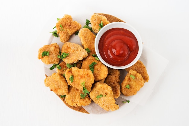 Hausgemachte Hühnernuggets mit Ketchup auf einem Holzbrett