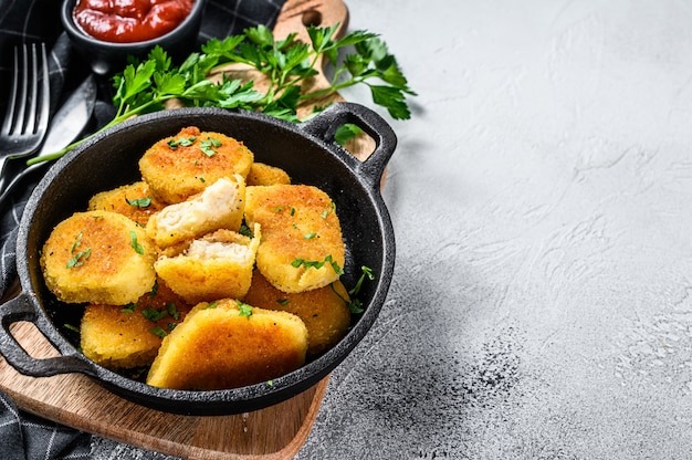 Hausgemachte Hühnernuggets und Ketchup-Sauce in einer Pfanne. Grauer Hintergrund. Draufsicht. Speicherplatz kopieren