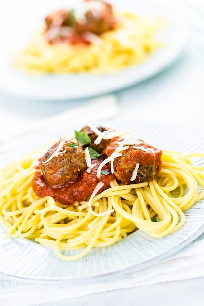 Hausgemachte italienische Fleischbällchen garniert mit Koriander und Parmesan über Spaghetti zum Abendessen.