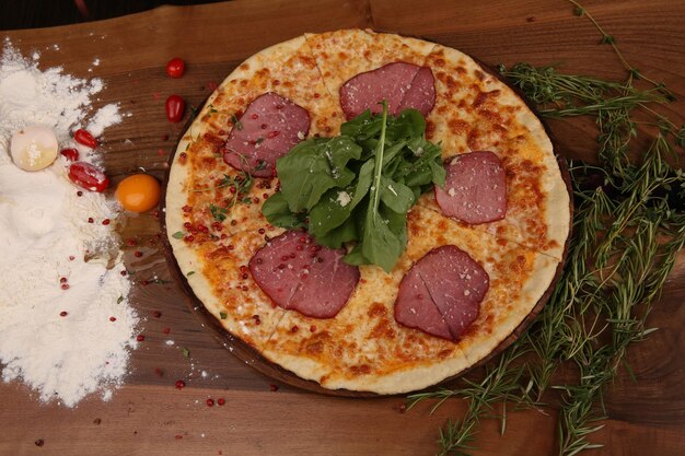 Hausgemachte italienische Pizza mit Mozzarella-Käse-Salami-Tomatensauce-Pfeffer-Rucola und Gewürzen