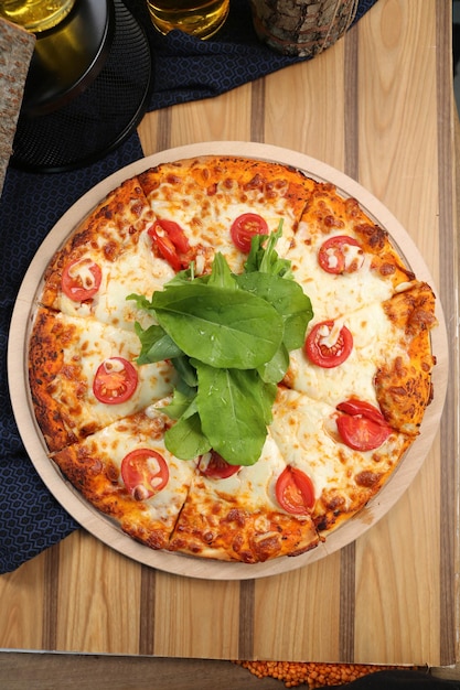 Foto hausgemachte italienische pizza mit mozzarella-käse-salami-tomatensauce-pfeffer-rucola und gewürzen