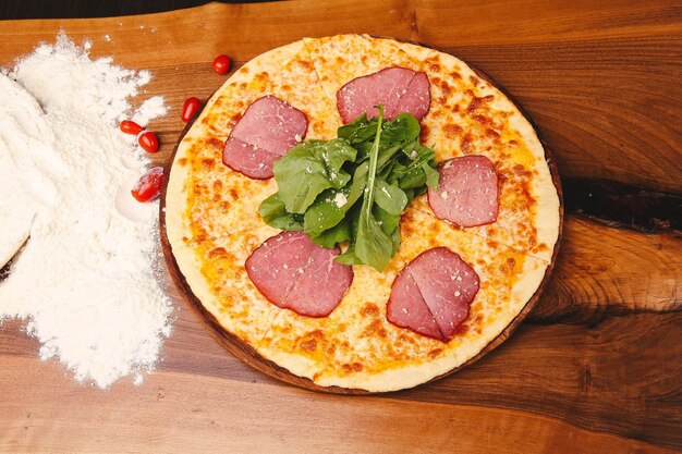 Hausgemachte italienische Pizza mit Mozzarella-Käse-Salami-Tomatensauce-Pfeffer-Rucola und Gewürzen