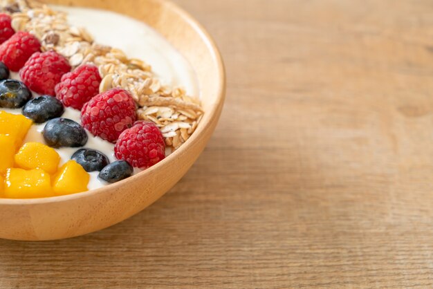 hausgemachte Joghurtschale mit Himbeere, Heidelbeere, Mango und Müsli. gesunder Ernährungsstil