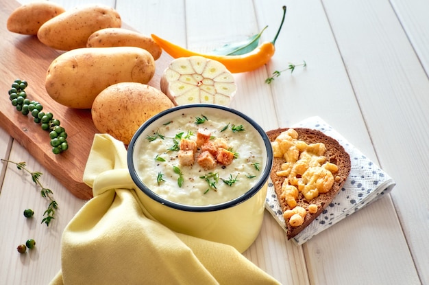 Hausgemachte Kartoffelcremesuppe mit Croutons, dazu geröstetes Brot mit Käse