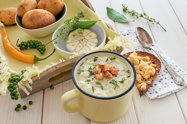 Hausgemachte Kartoffelcremesuppe mit Croutons und Thymian, dazu geröstetes Brot mit Käse