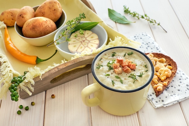 Hausgemachte Kartoffelcremesuppe mit Croutons und Thymian, dazu geröstetes Brot mit Käse