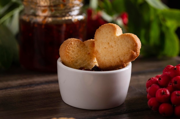 Foto hausgemachte kekse in herzform in einer schüssel mit marmelade