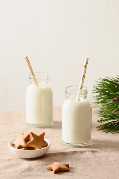 Hausgemachte Kekse und Milch in zwei Flaschen für den Weihnachtsmann auf dem Weihnachtstisch