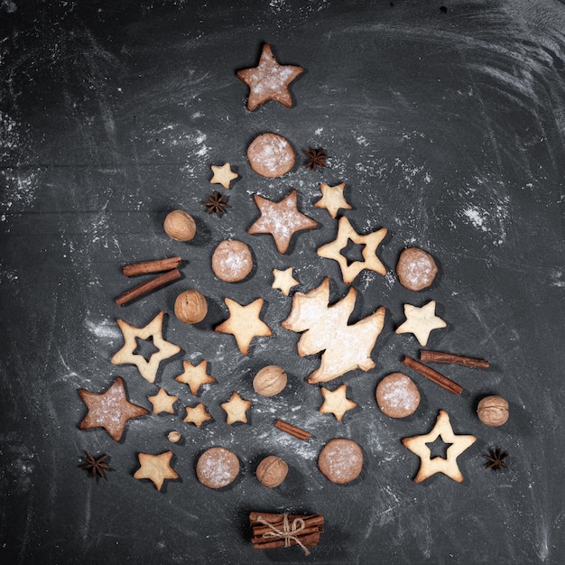 Foto hausgemachte kekse zimt walnüsse anis sterne als weihnachtsbaum auf schwarz ausgelegt