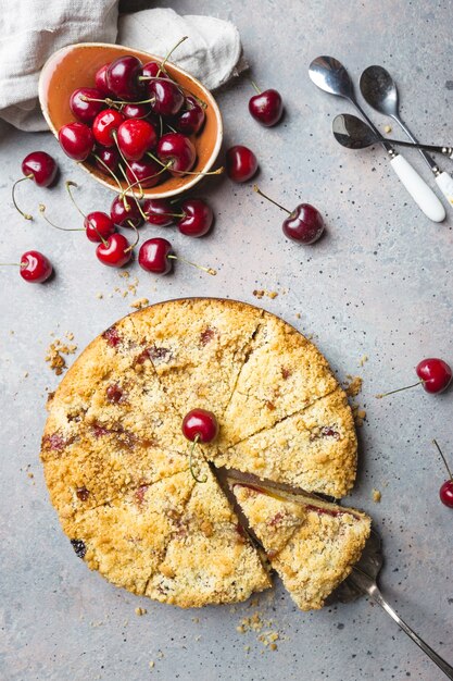 Hausgemachte Kirsch-Streusel-Torte mit frischen Beeren auf rustikalem