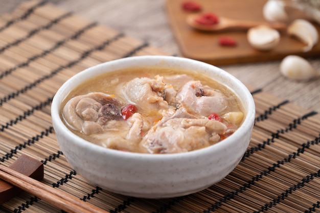 Hausgemachte köstliche Knoblauch-Hühnersuppe in einer Schüssel auf dunklem Holztisch