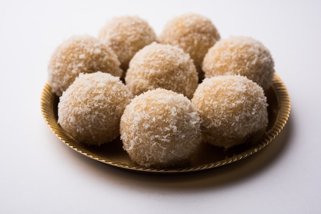 Hausgemachte Kokosnuss Sweet Laddoo ODER Nariyal Laddu mit Kondensmilch und Zucker, beliebtes Festivalessen. Serviert über stimmungsvollem Hintergrund, selektiver Fokus