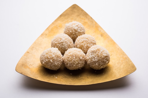 Hausgemachte Kokosnuss Sweet Laddoo ODER Nariyal Laddu mit Kondensmilch und Zucker, beliebtes Festivalessen. Serviert über stimmungsvollem Hintergrund, selektiver Fokus