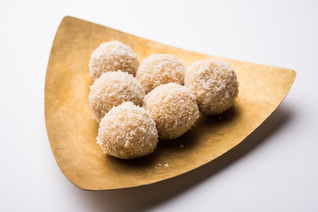 Hausgemachte Kokosnuss Sweet Laddoo ODER Nariyal Laddu mit Kondensmilch und Zucker, beliebtes Festivalessen. Serviert über stimmungsvollem Hintergrund, selektiver Fokus