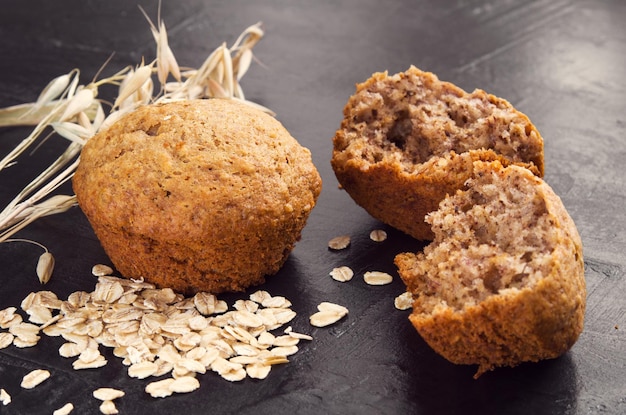 Hausgemachte Kuchen aus Hafermehl, Haferflocken und Weizenähren auf dunklem Hintergrund Soncept von hausgemachten gesunden Lebensmitteln