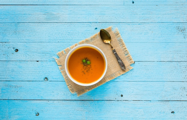 Hausgemachte Kürbissuppe auf rustikalem hölzernem Hintergrund, freier Raum für Text.