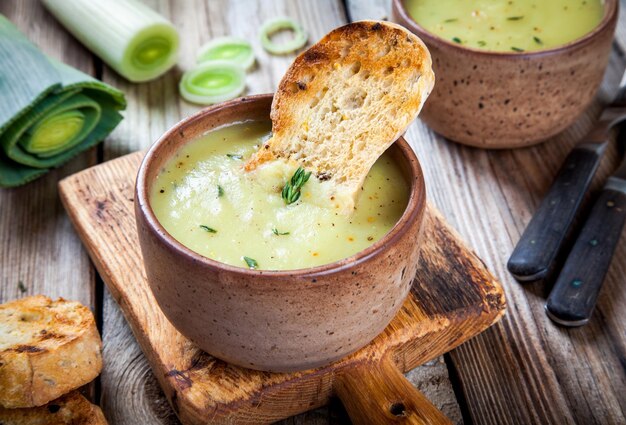 Hausgemachte Lauchcremesuppe mit Croutons auf Holztisch