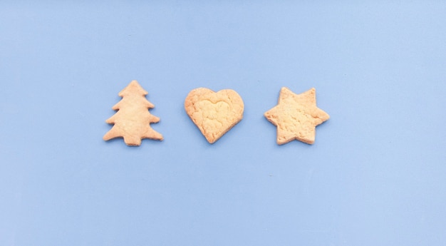 Hausgemachte Lebkuchen in verschiedenen Formen, auf blauem Hintergrund isoliert. Flache Lage mit Weihnachtsplätzchen, die in Kreisform angezeigt werden.