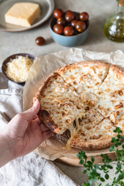 Hausgemachte leckere heiße Pizza mit Hühnchen und Scheibe mit schmelzendem Käse