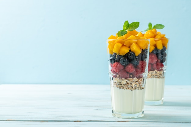 hausgemachte Mango, Himbeere und Blaubeere mit Joghurt und Müsli - gesunde Ernährung