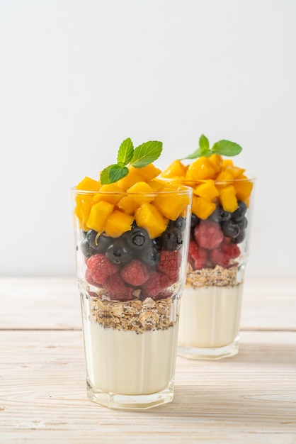 hausgemachte Mango, Himbeere und Blaubeere mit Joghurt und Müsli - gesunde Ernährung