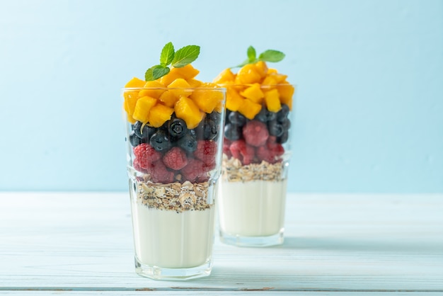 hausgemachte Mango, Himbeere und Blaubeere mit Joghurt und Müsli - gesunde Ernährung