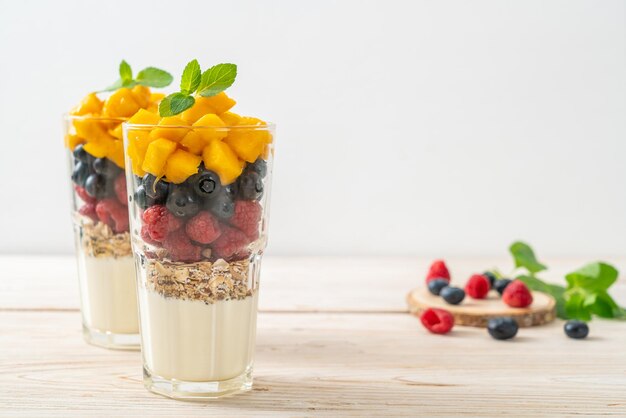 hausgemachte Mango, Himbeere und Blaubeere mit Joghurt und Muesli