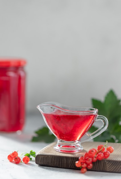 Hausgemachte Marmelade aus roten Johannisbeeren in einem Sauciere, frische Beeren