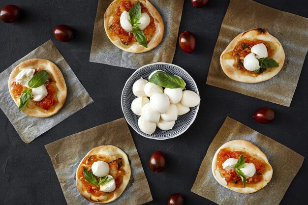 Hausgemachte Mini-Pizza Margarita mit Tomaten, Mozzarella und Basilikum