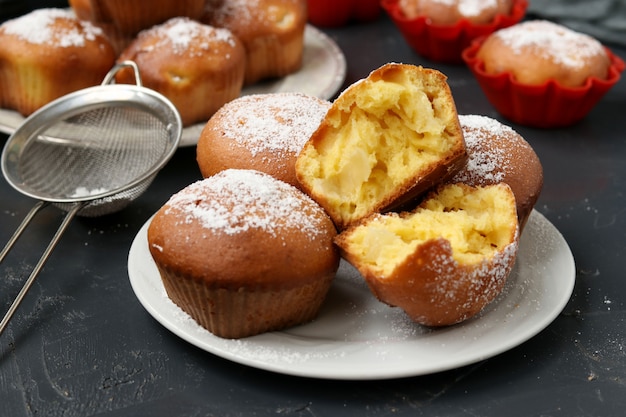 Hausgemachte Muffins mit Ananasstücken, bestreut mit Puderzucker