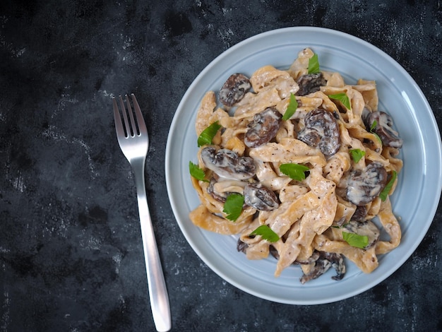 Hausgemachte Nudeln mit Champignons und Carbonara-Sauce.